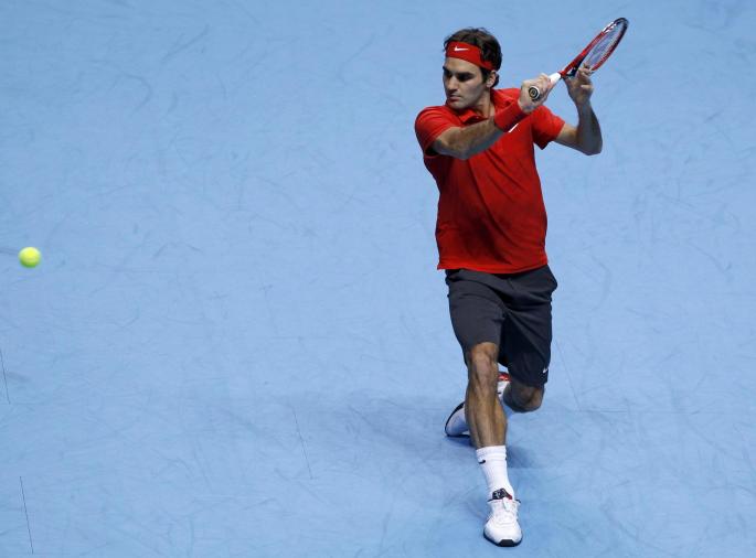 Switzerland's Federer hits a return to Britain's Murray during their singles tennis match at the ATP World Tour Finals in London