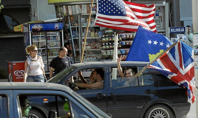 Passengers wave the U.S., Kosovo and British flags as they celebrate in capital Pristina after the World Court said Kosovo's dec