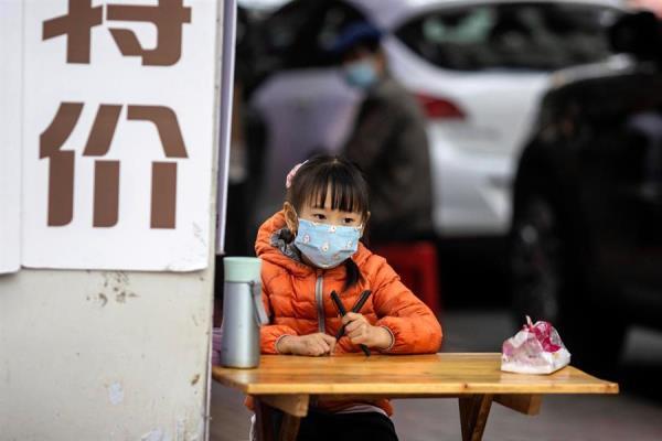 Una niña utiliza mascarilla en China