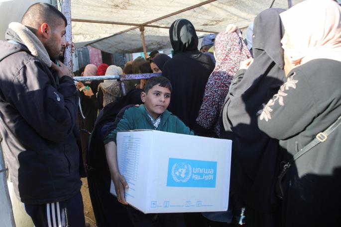 Palestinians receive aid following a ceasefire between Israel and Hamas, in Khan Younis in the southern Gaza Strip
