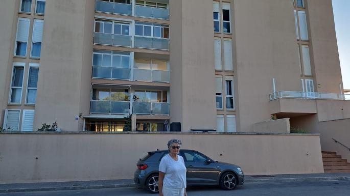 María Elena Collado posa ante su piso, que no puede recuperar y del que le deben más de 15.000 euros de renta