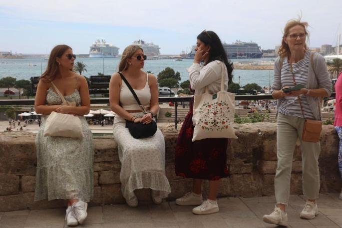 Cuatro mujeres sentadas frente a la Catedral de Palma.