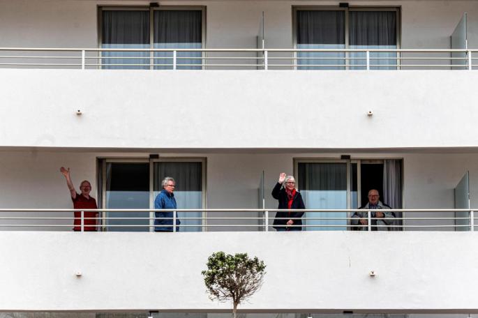 Varios turistas saludan desde las terrazas de sus habitaciones de un hotel del Arenal en Llucmajor