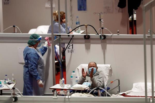 Un paciente del hospital de campaña provisional instalado en Ifema aplaude la lectura del Quijote, con motivo del Día del Libro
