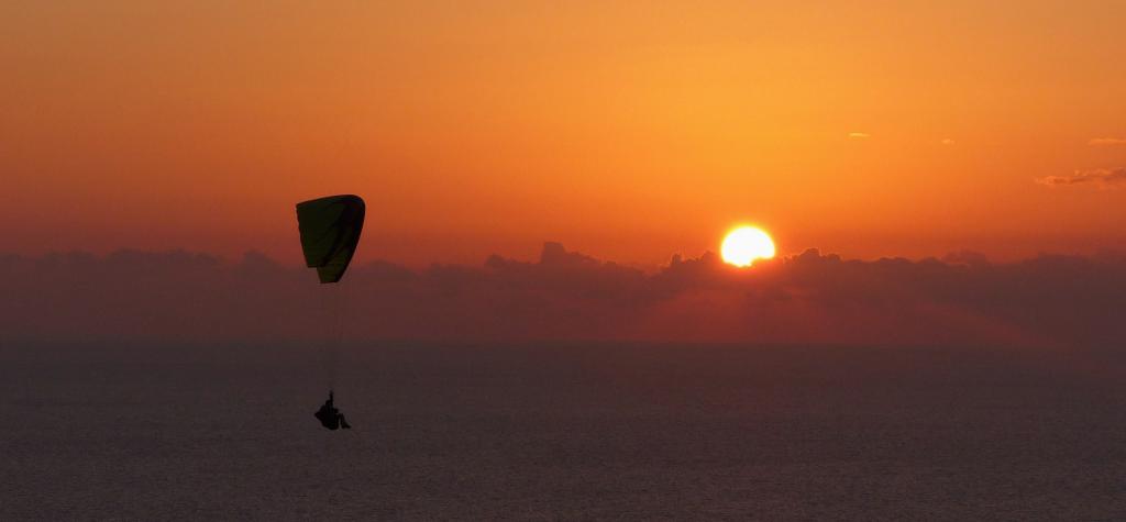 ultraligero volando en la puesta de sol