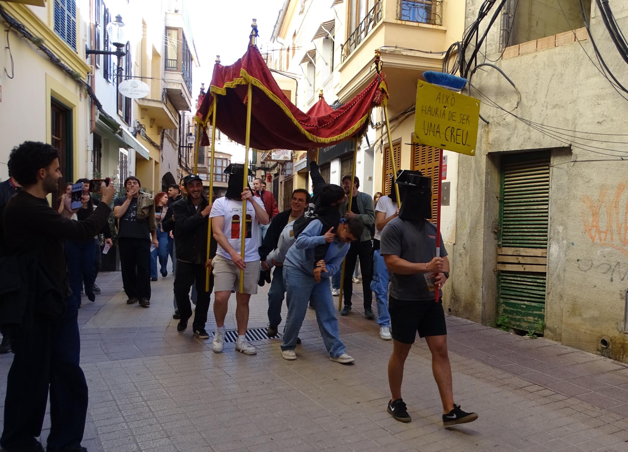 Una ‘procesión’ irónico-festiva con una cruz bajo palio divide Felanitx