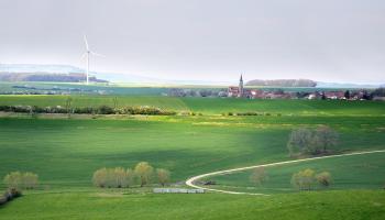 Molinos de viento eléctricos construidos en un prado en una zona rural, cerca de las montañas.