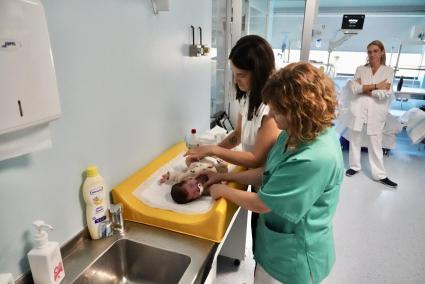 Rocío Bueno cambia el pañal de Ander ante la mirada de una enfermera.