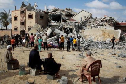 Palestinos miran una casa destruida en Gaza.