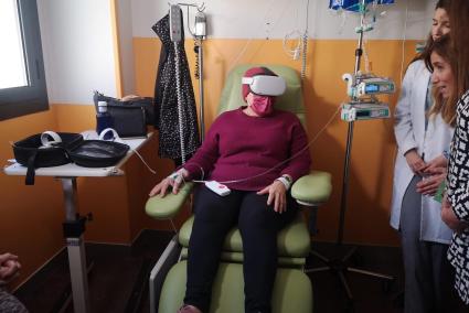 Una paciente recibe una sesión de quimioterapia mientras disfruta de una proyección de realidad virtual.