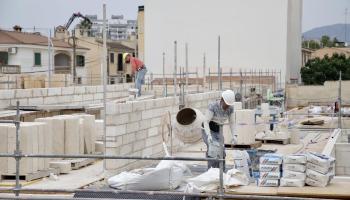 Dos obreros de la construcci&oacute;n trabajando en una edificaci&oacute;n en Palma.