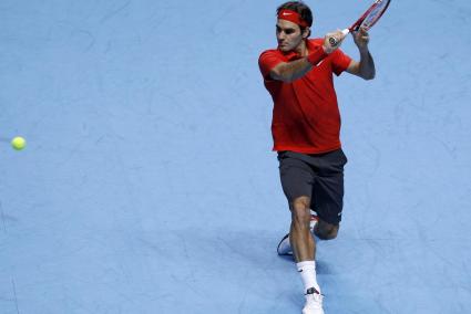 Switzerland's Federer hits a return to Britain's Murray during their singles tennis match at the ATP World Tour Finals in London