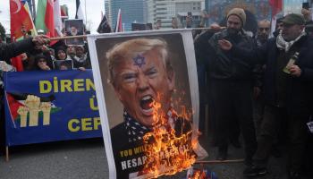 Un grupo de persona quema una foto de Trump en protesta por el ataque a Irán.