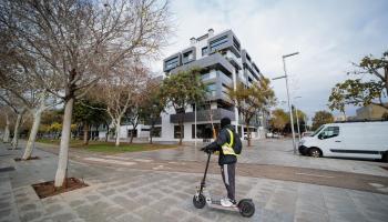 Un hombre en patinete pasa por las nuevas viviendas de lujo del barrio palmesano de Nou Llevant.
