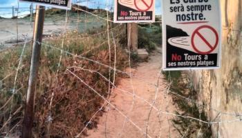 Carteles y alambres que cortan el paso.