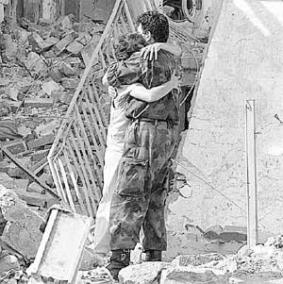 Un soldado serbio abraza a una mujer frente a una casa destruida en un bombardeo, en Aleksinac.