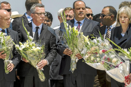 Ministers pay their respects in front of a makeshift memorial at the beachside of the Imperial Marhaba resort, which was attacke