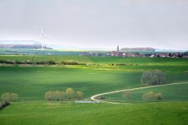 Molinos de viento eléctricos construidos en un prado en una zona rural, cerca de las montañas.