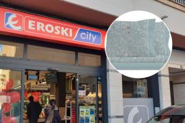 Vista general de un supermercado Eroski y en el círculo un juego de sábanas de la marca Antonio Miró